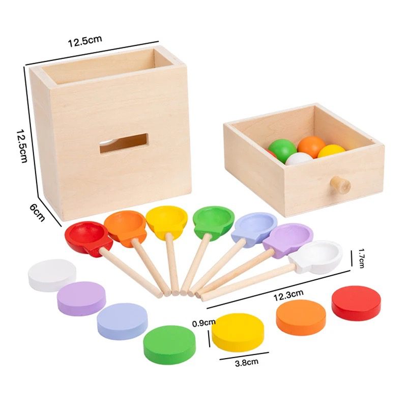 Wooden Montessori object permanence box with measurement dimensions, color balls, scooping spoons, and sorting discs for fine motor skill and hand-eye coordination development in toddlers.