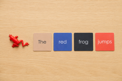 Montessori Phonetic Farm Game colour-coded sentence cards showing the red frog jumps with red frog figurine