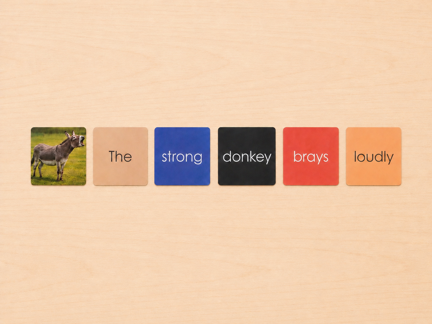 Montessori Non-Phonetic Farm Game colour-coded sentence cards showing the strong donkey brays loudly with donkey figurine
