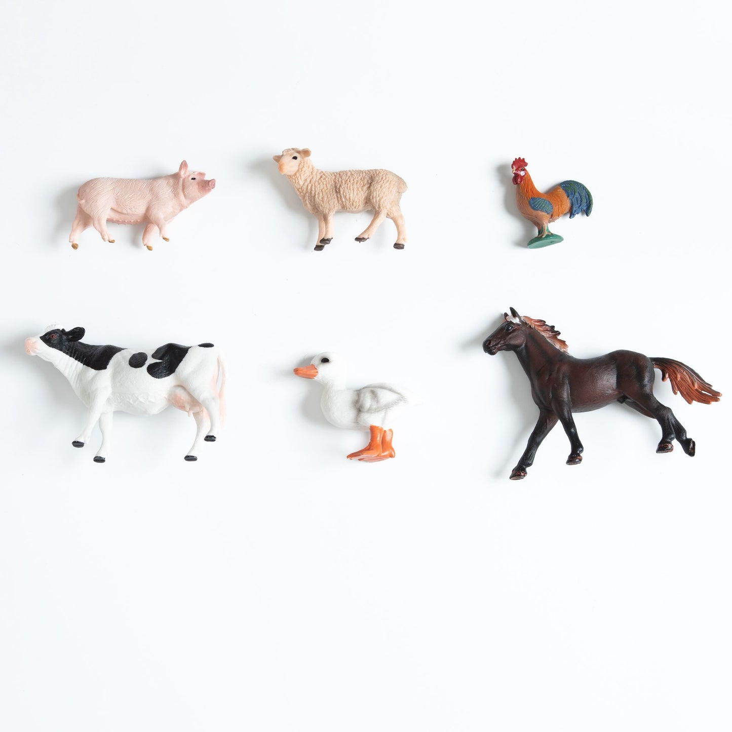 Individual farm animal figurines arranged for Montessori toddler matching and vocabulary work