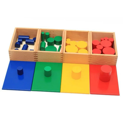 Open wooden boxes containing Montessori knobless cylinders with matching colored lids placed in a row.
