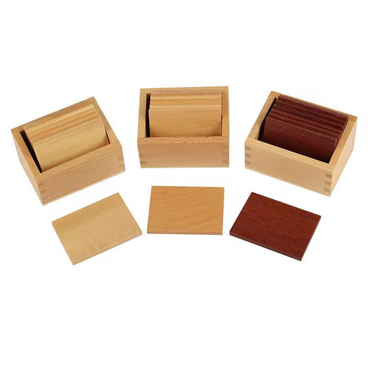 Montessori baric tablets set with three wooden boxes and graded wooden weight tablets for pressure and weight discrimination activities.