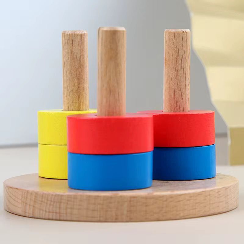 Montessori wooden color stacking rings placed on pegs for toddler fine motor coordination and color discrimination