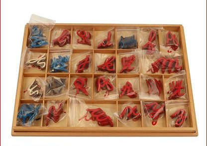 Wooden tray containing Montessori cursive movable alphabet letters individually packed in plastic bags