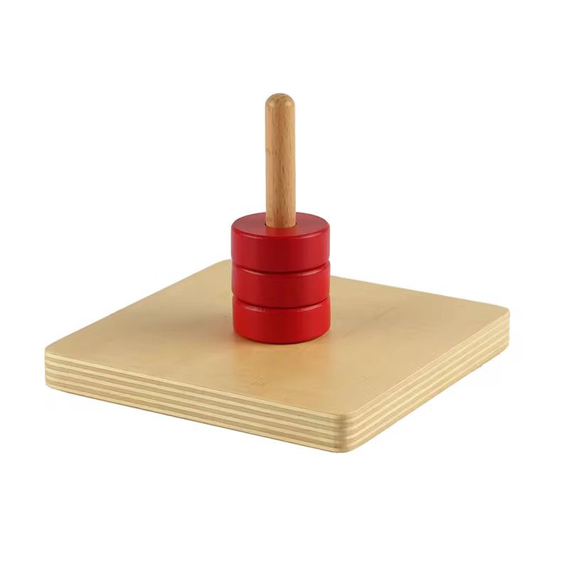 Montessori discs on vertical dowel stacked for toddler fine motor coordination and controlled hand movement