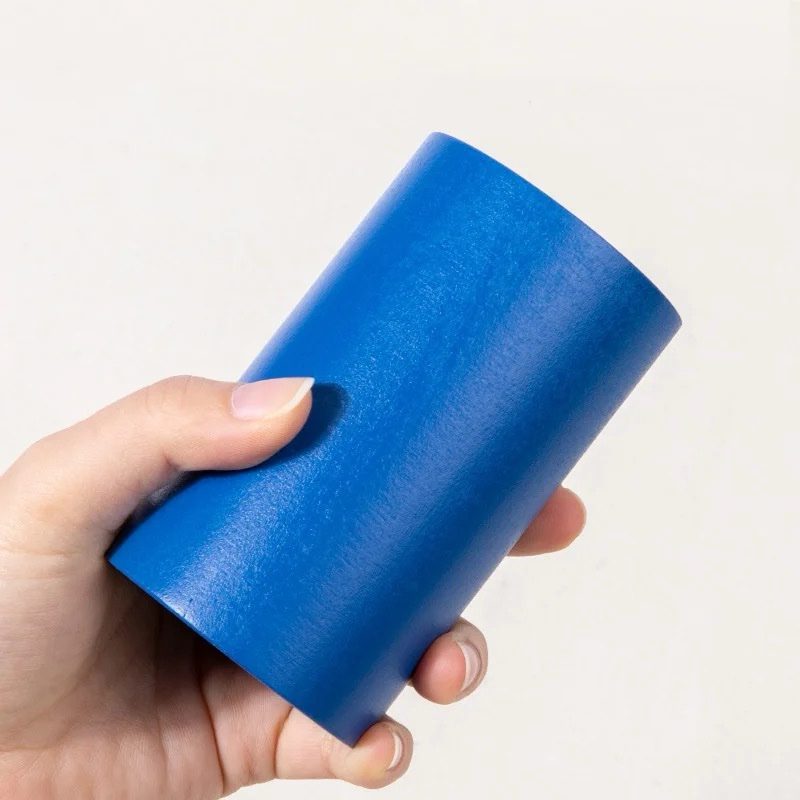 Hand holding a blue Montessori geometric solid cylinder for sensorial shape exploration