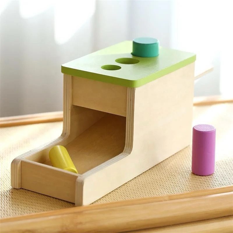 Front view of Montessori wooden peg drop box with sliding tray and colorful pegs