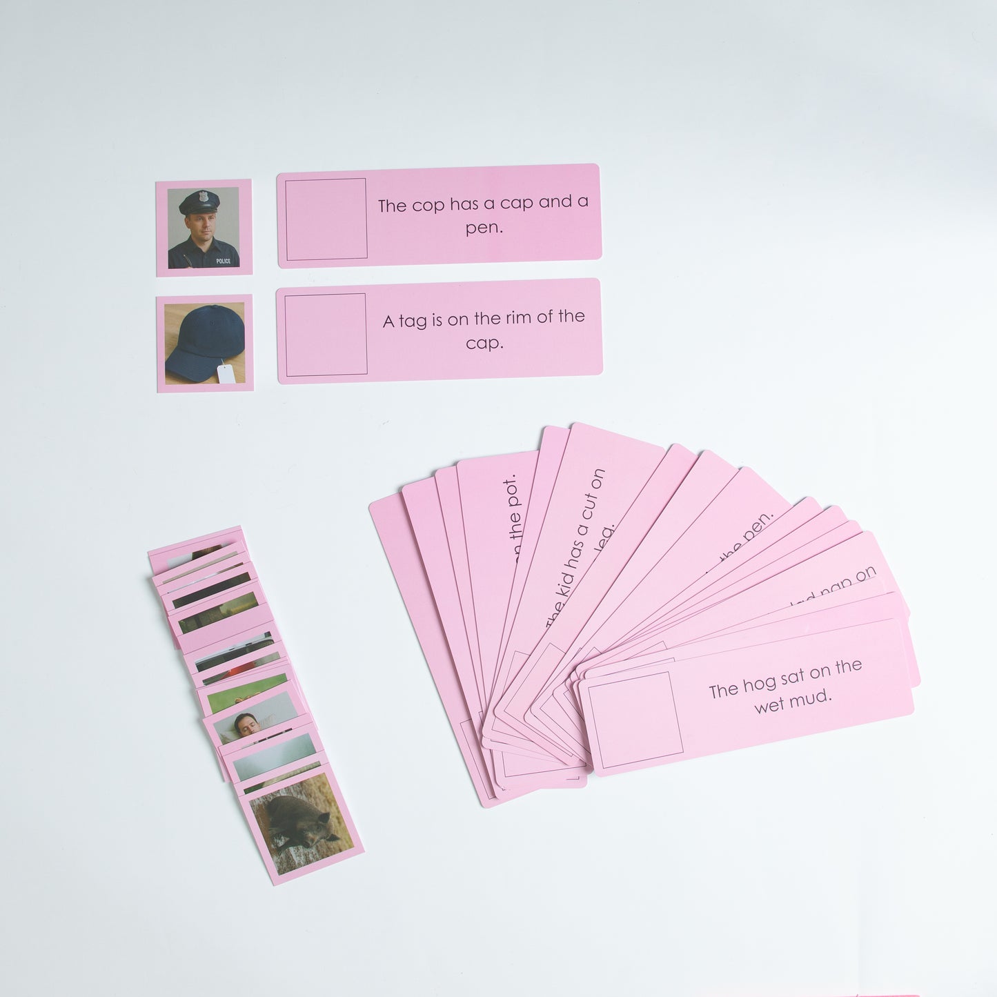 Montessori Pink Series detached sentence cards with matching picture cues for decoding and reading fluency.