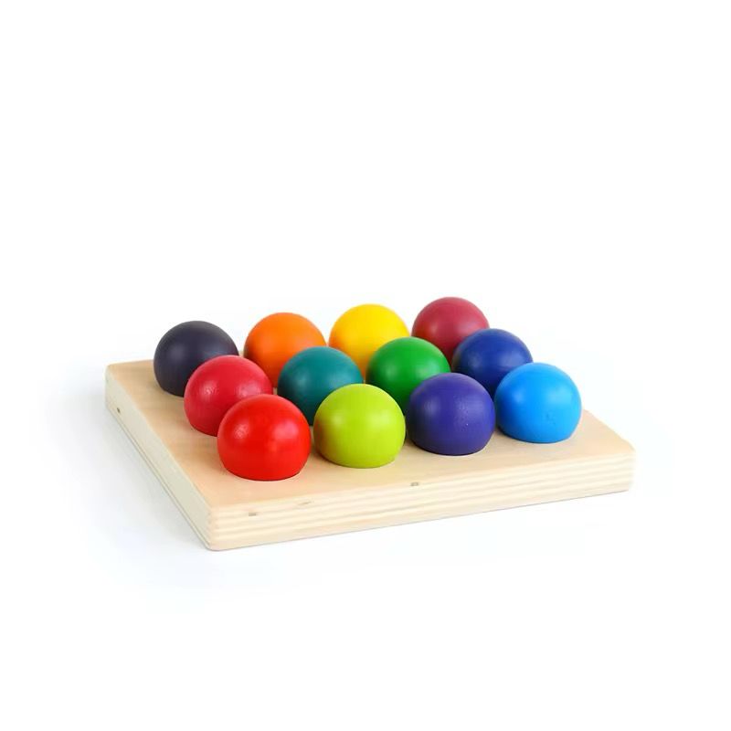 Montessori rainbow ball matching board with all wooden balls arranged for toddler visual discrimination and coordination