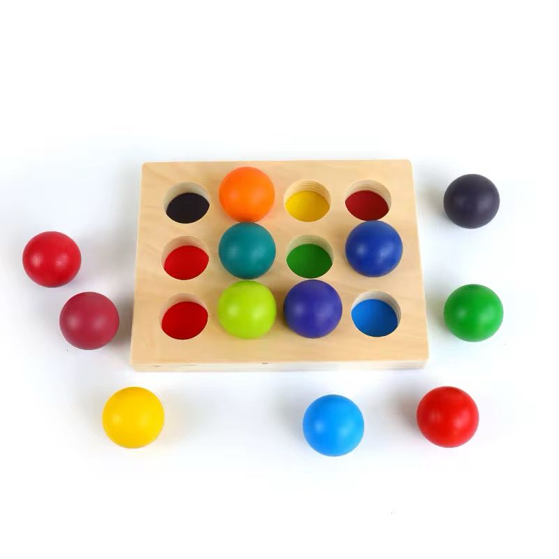 Montessori wooden ball sorting game top view showing color matching holes and loose rainbow balls for preschool learning