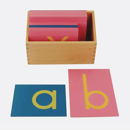 Montessori sandpaper lowercase letters displayed with a wooden storage box showing the letters “a” and “b”