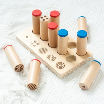 Montessori sound and pattern cylinders removed from tray for matching and sensory exploration.