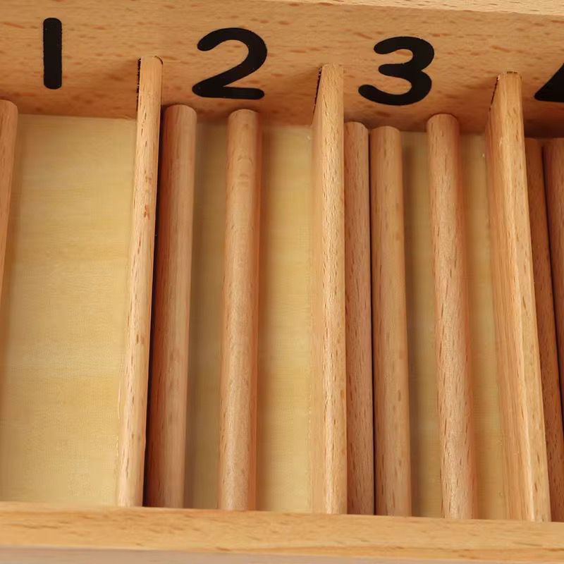 Close-up view of the Montessori spindle box showing numbered compartments and neatly arranged wooden spindles.