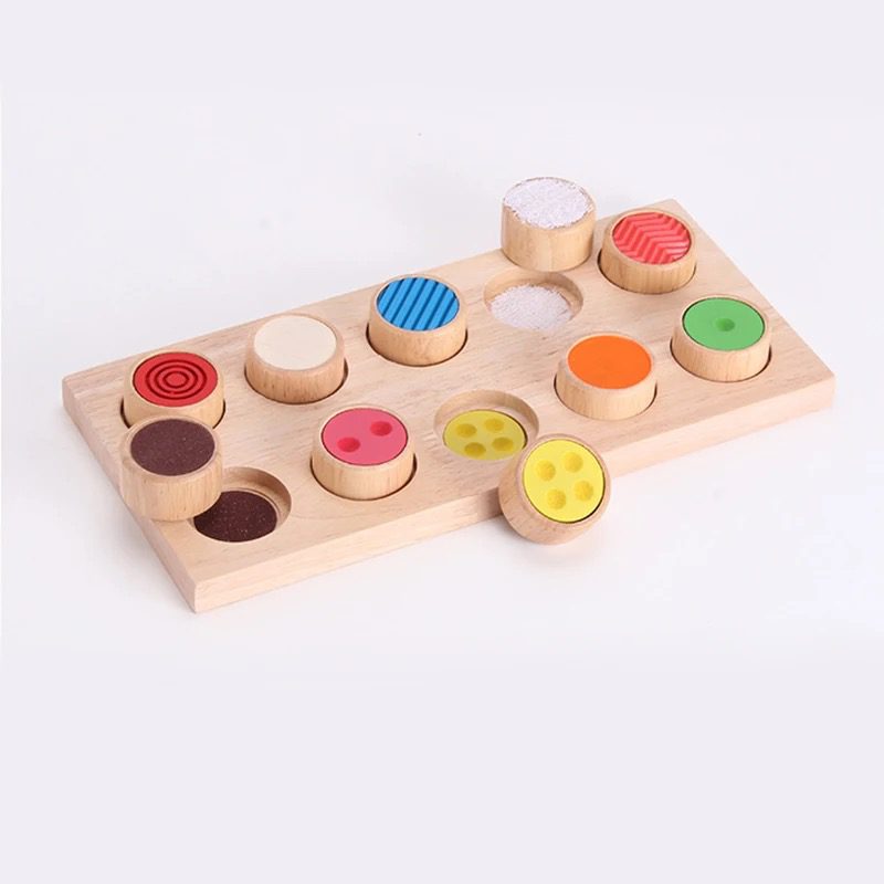 Montessori tactile sensory set featuring removable textured cylinders placed around the matching board.