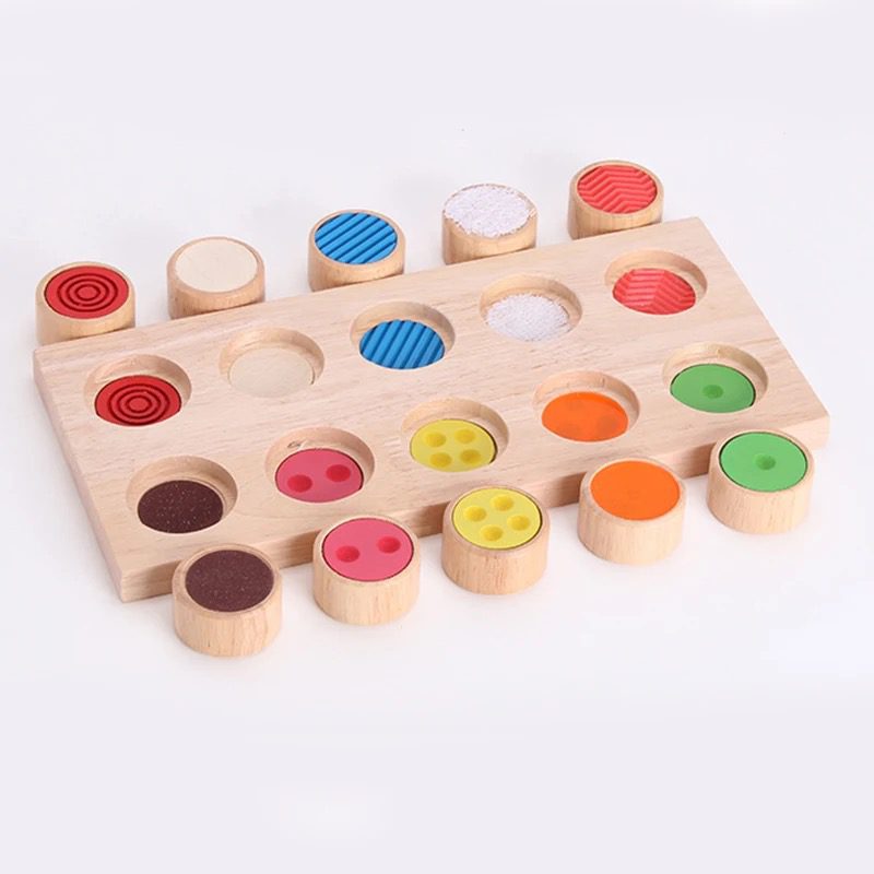 Montessori texture matching set showing wooden cylinders removed from the board to display different textured surfaces