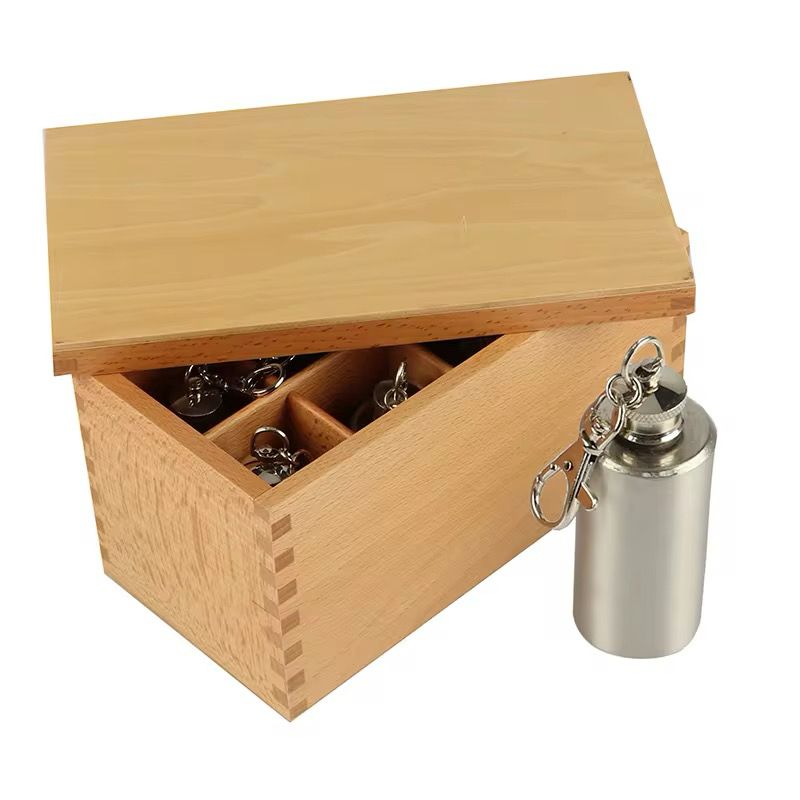 Thermic bottles shown with the wooden lid open, demonstrating storage and presentation of the Montessori material.