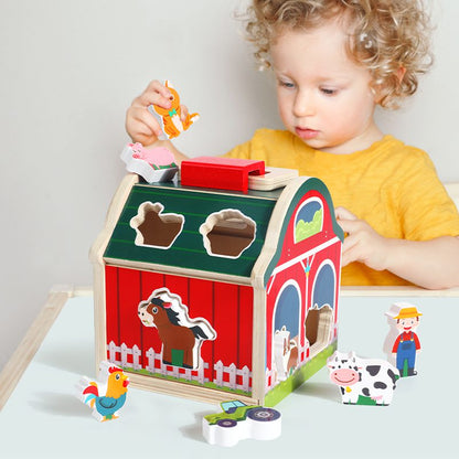 Toddler playing with wooden farm shape sorting barn for learning and fine motor skills