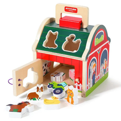 Wooden farm toy with open door showing storage space for animal blocks