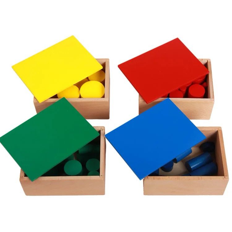 Montessori knobless cylinders stored inside wooden boxes with colored lids in yellow, red, green, and blue