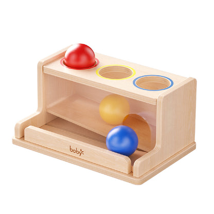 Montessori wooden ball drop box with colorful balls and matching holes, designed to develop fine motor skills, hand-eye coordination, color recognition, and object permanence for toddlers.