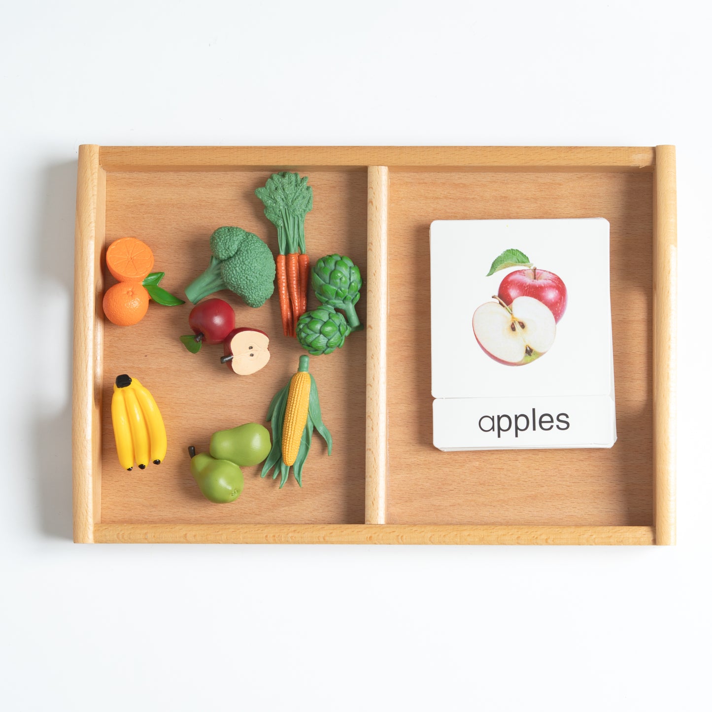 Montessori fruits and vegetables classification set with mini food objects and 3-part nomenclature cards arranged on a wooden tray