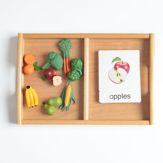 Montessori fruits and vegetables classification set with mini food objects and 3-part nomenclature cards arranged on a wooden tray