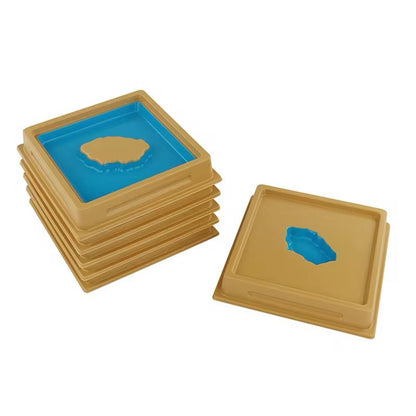 Stacked Montessori land and water form trays showing wooden geography materials