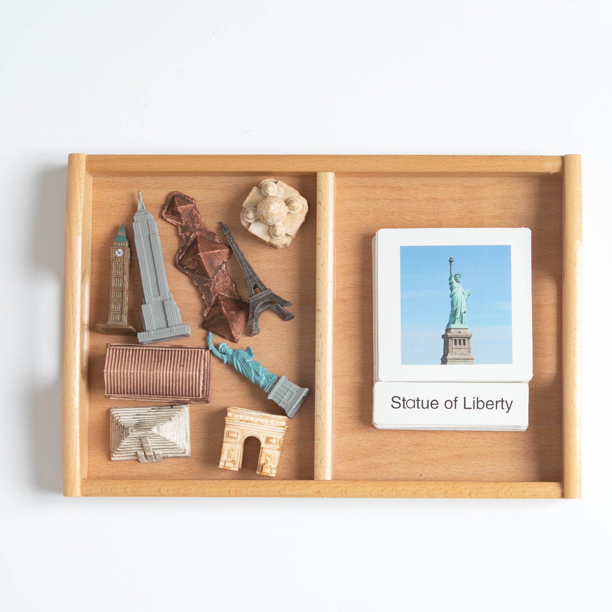 Montessori world landmarks classification set with mini objects and 3-part nomenclature cards arranged on a wooden tray