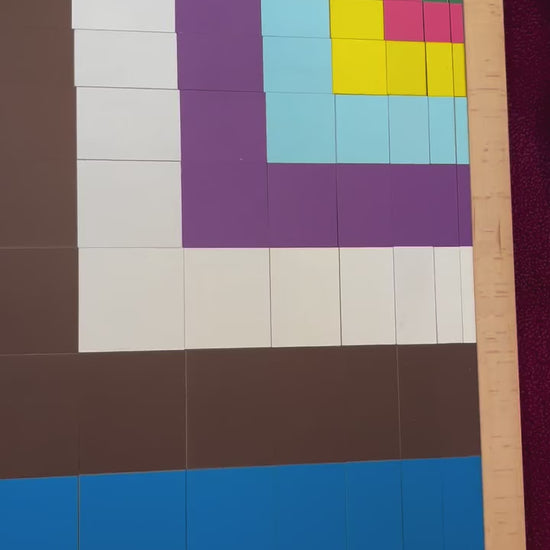 Close-up view of colorful geometric block pattern arranged inside a wooden learning board.