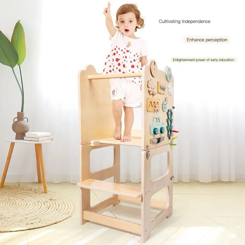 Toddler standing safely on convertible kitchen helper learning tower while engaging in kitchen activity