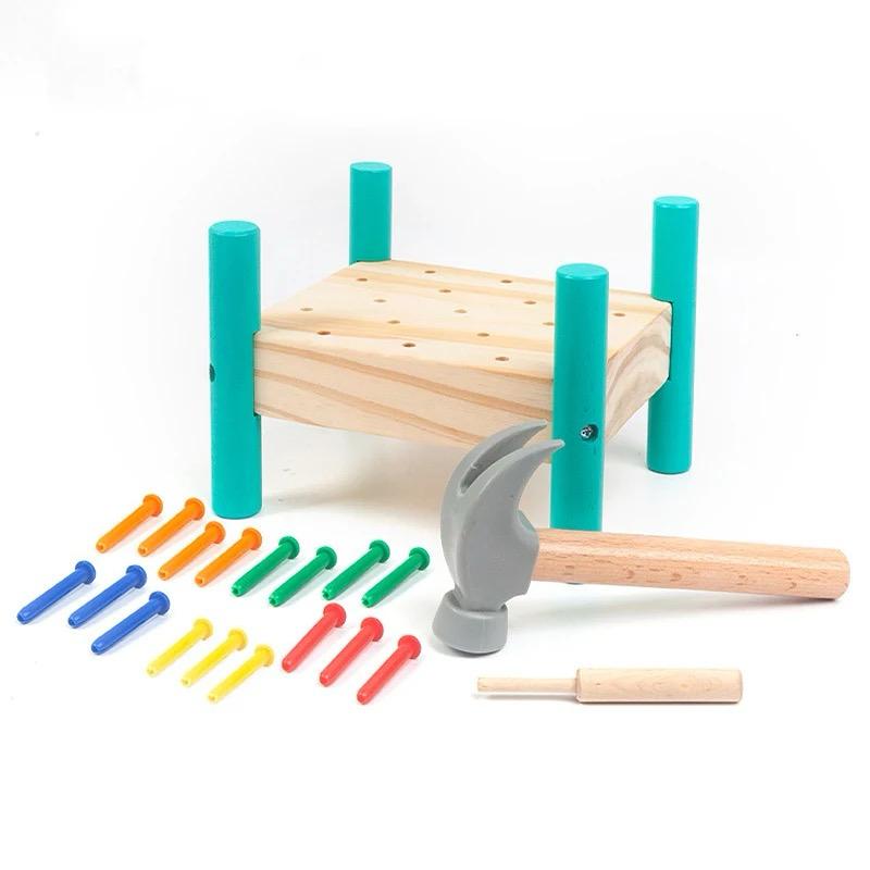 Wooden hammering toy components including hammer, pegs, and knock nail table for hands-on play